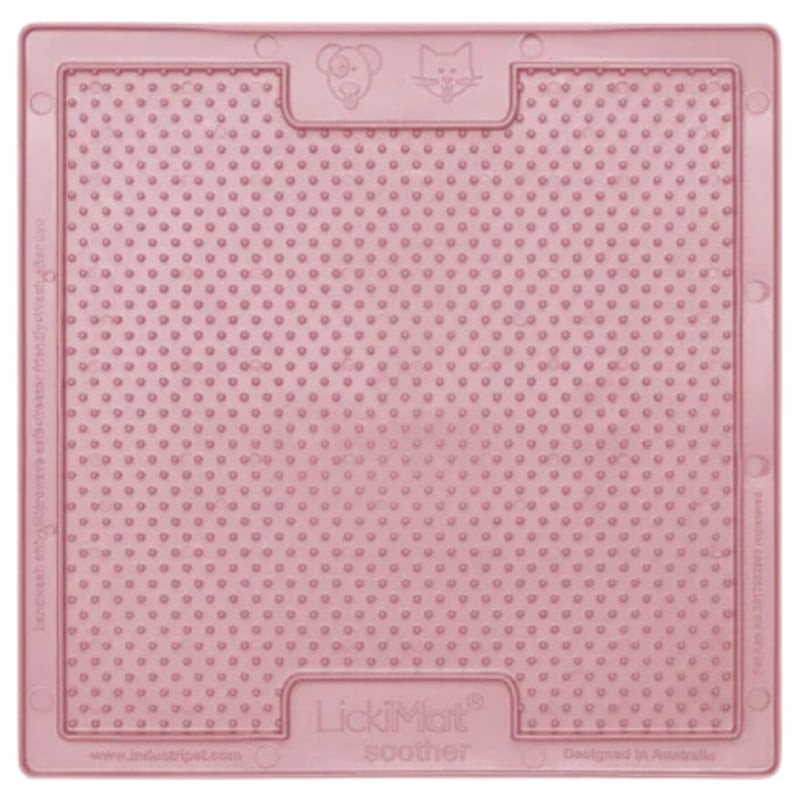 Main tenant le LickiMat Soother Classic goyave pour montrer sa taille et sa flexibilité.