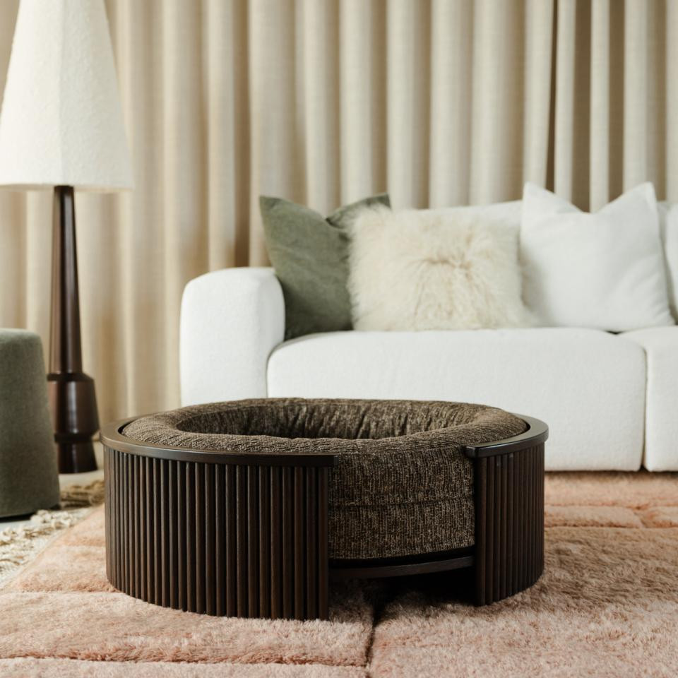 Fantail 1083708 walnut wood dog bed frame placed near a window, with a dog sleeping.