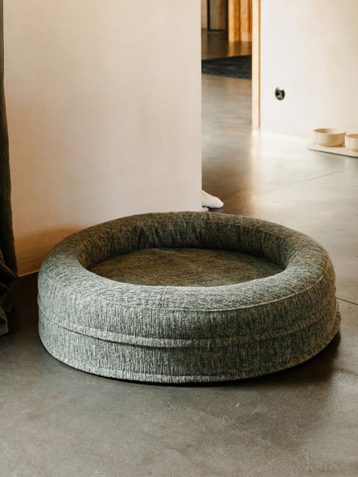 A large dog resting comfortably on the Fantail Elite Forest orthopedic cushion in a cozy living room