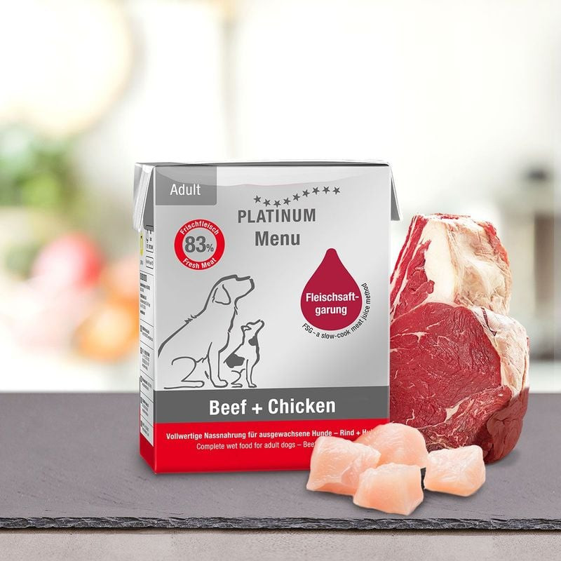 Pâtée Platinum 1083657 Bœuf + Poulet pour chien présentée avec steak de bœuf frais et morceaux de po