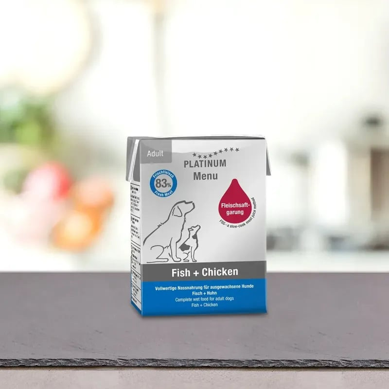 Photo ambient de la pâtée PLATINUM 1083648 Poisson + Poulet en carton sur ardoise sombre en cuisine,