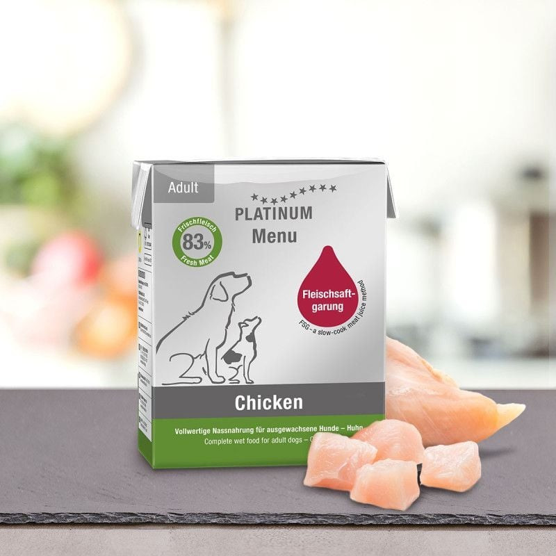Image lifestyle de la pâtée PLATINUM Menu Adult Chicken 375g sur table avec morceaux de poulet frais
