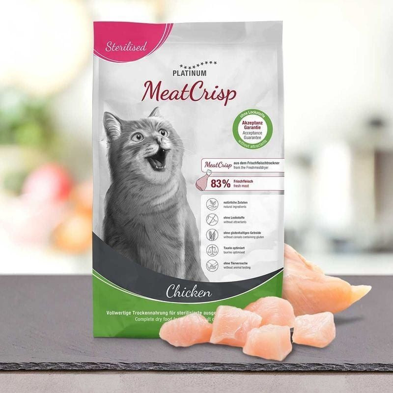 Un chat s'approchant d'un bol de croquettes PLATINUM MeatCrisp Stérilisé Poulet dans un cadre domest