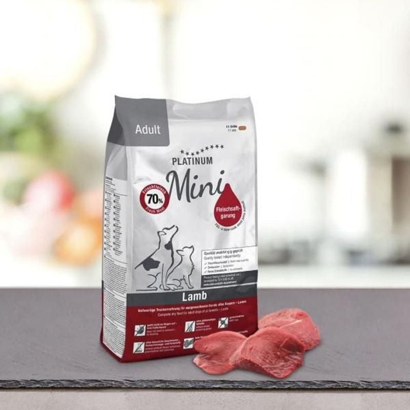Sac de croquettes Platinum Adult Agneau Mini 900g en cadre naturel sur table avec tranches d'agneau 