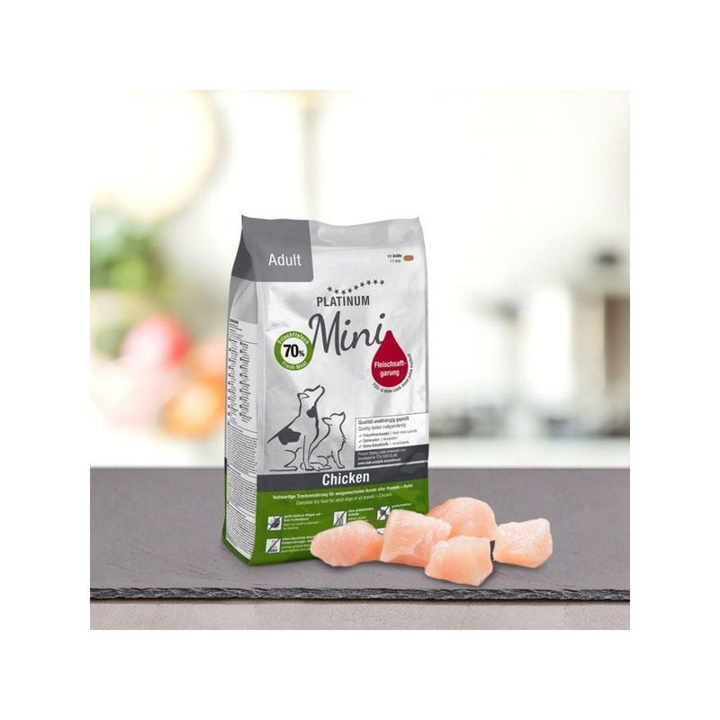 Paquet Platinum Adult Chicken Mini 900g sur comptoir de cuisine avec morceaux de poulet rose frais à