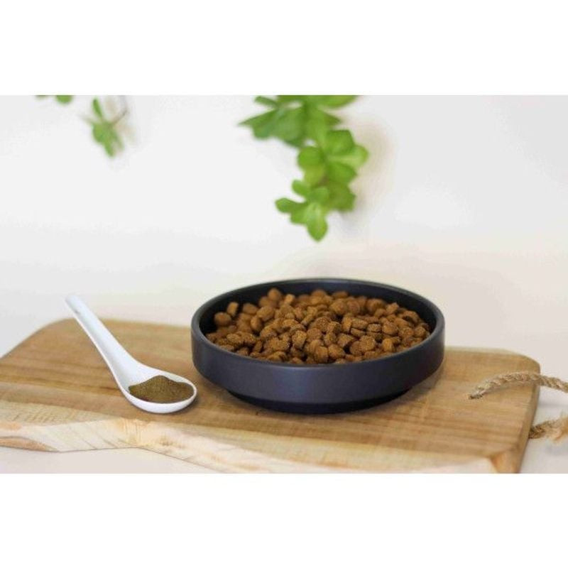 Granulés de complément Kelp Les Recettes de Daniel dans bol noir avec cuillère sur planche bois, fon