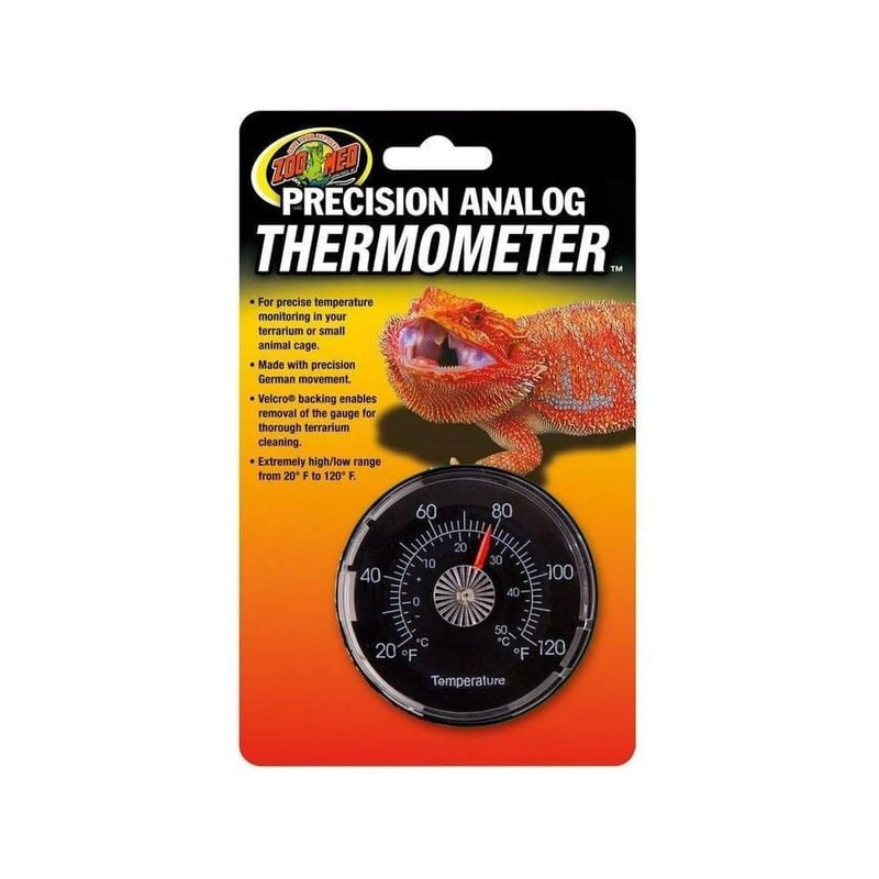 Gros plan thermomètre analogique Zoo Med sur emballage jaune-orange, cadran noir circulaire avec aig