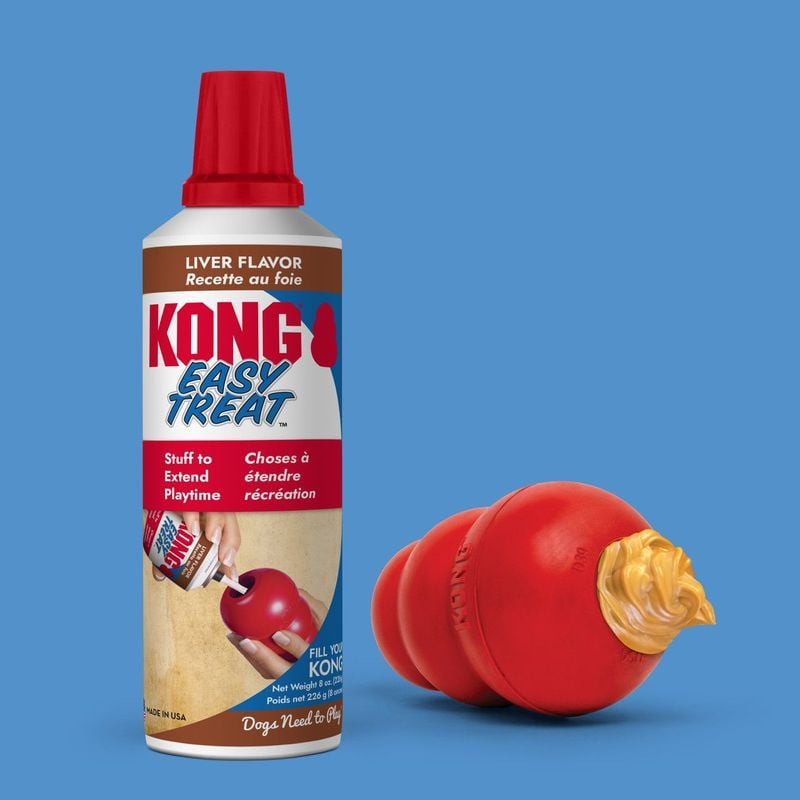 Tube KONG Pâte à tartiner foie 227g à côté d'un jouet KONG rouge avec pâte brune appliquée dessus, d