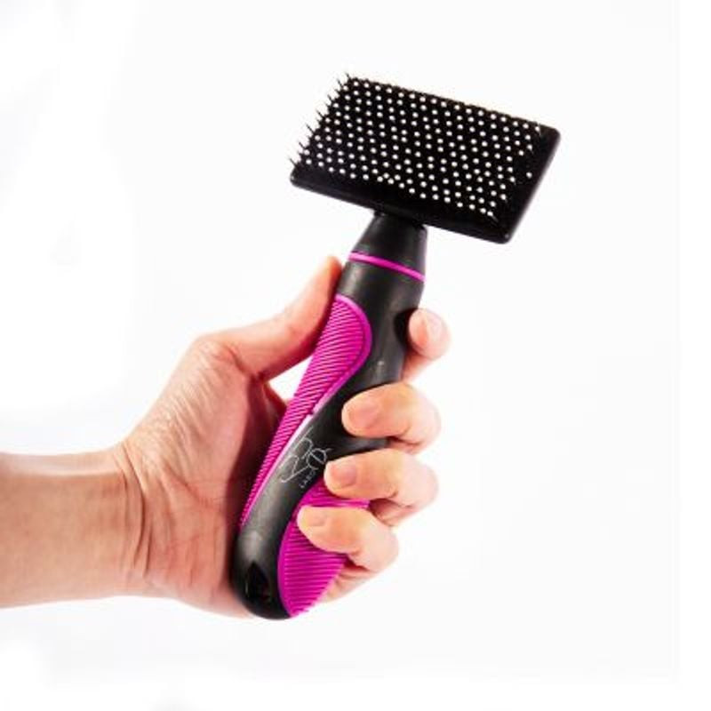Carde douce pour chat HERY M brossant un chat à poils longs lors d'un toilettage doux.